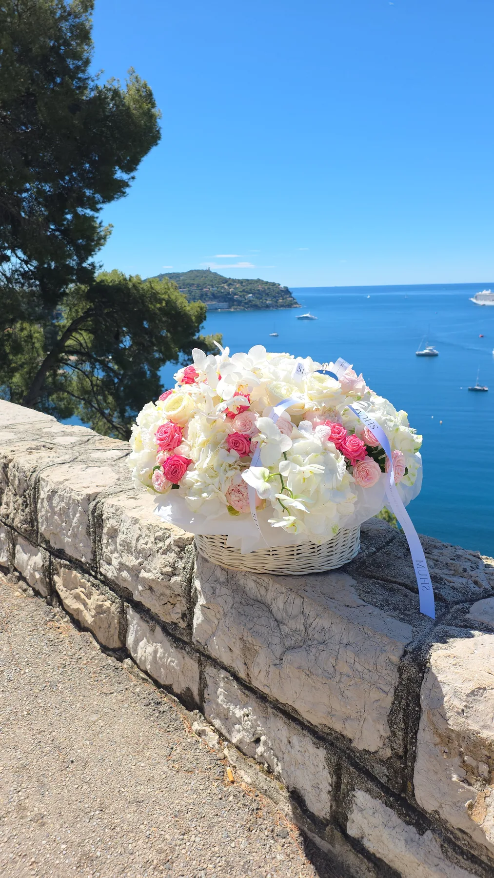 A basket of white and pink roses on a wall above the bay