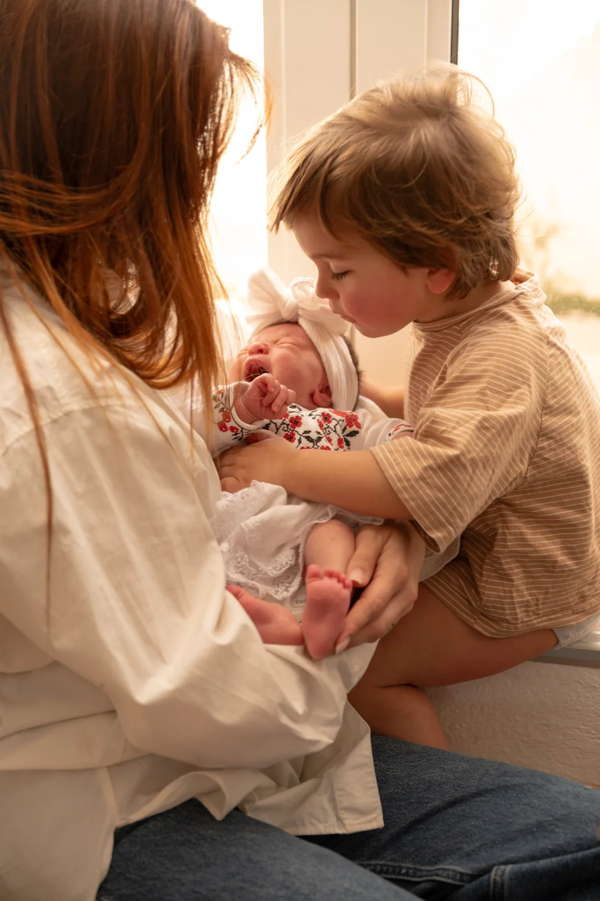 A mother with her newborn and her older daughter