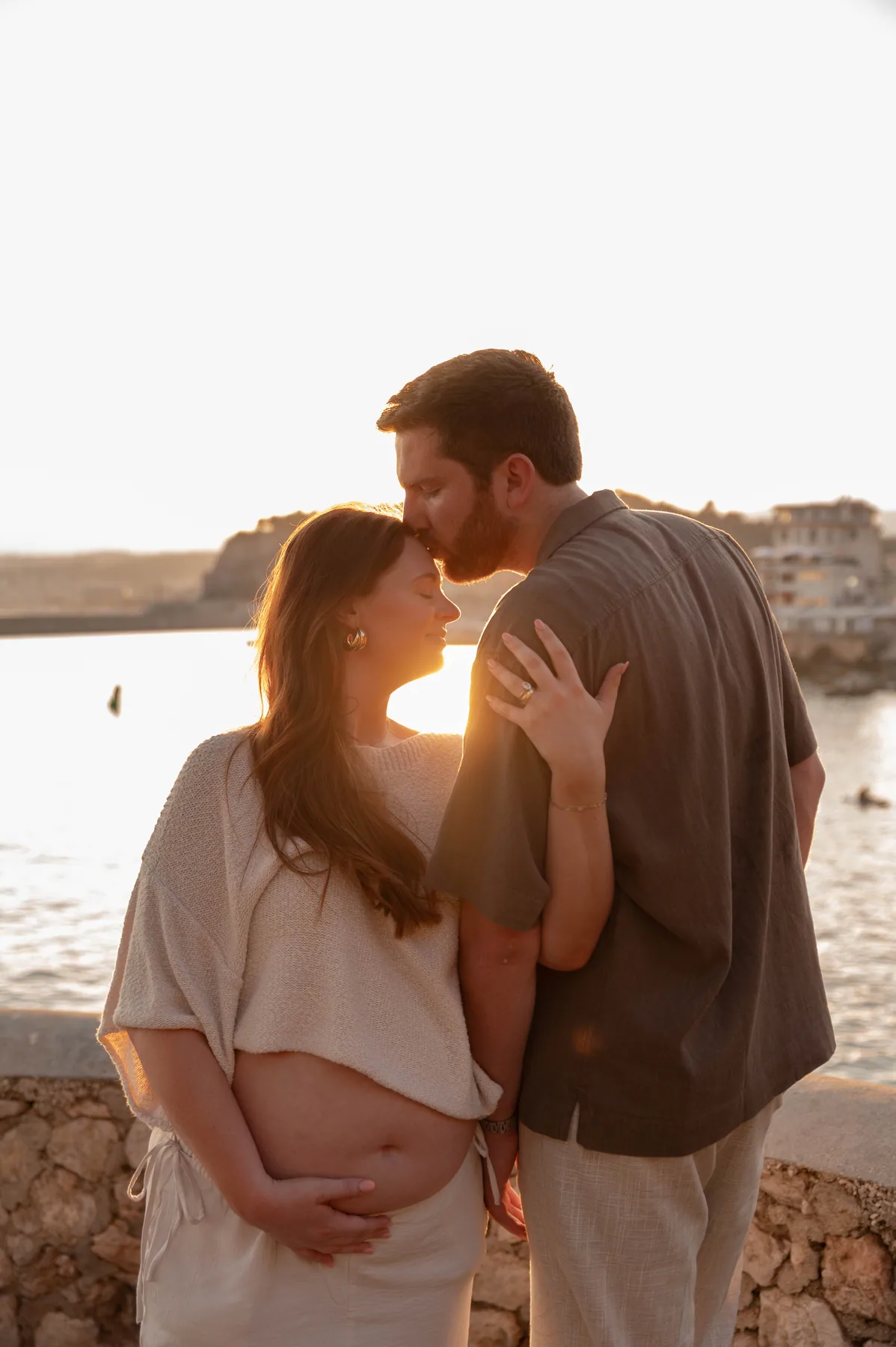 An expecting couple at sunset